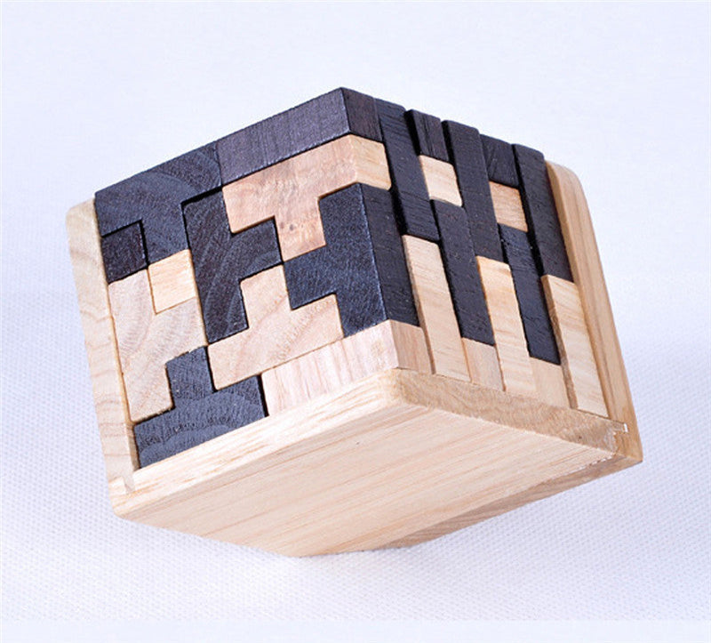 Wooden and black puzzle cube on a light background