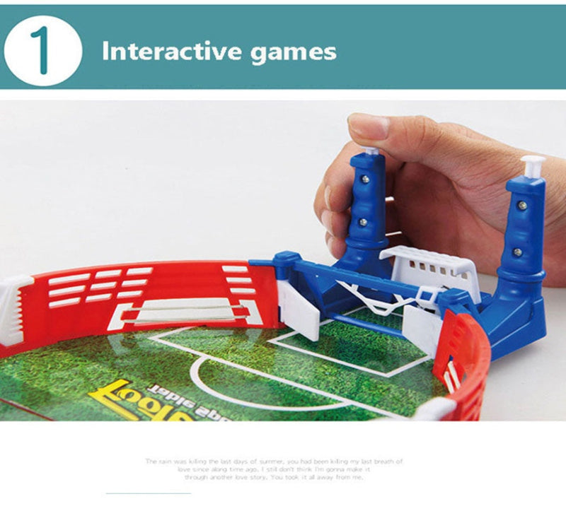Hand holding a small sports game set with red, white, and blue elements on a green playing field.