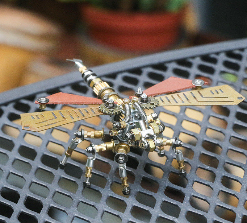 Metallic insect sculpture on a perforated metal surface