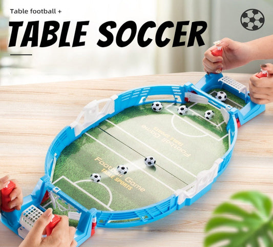 Table football game with players using red handles on a wooden table.