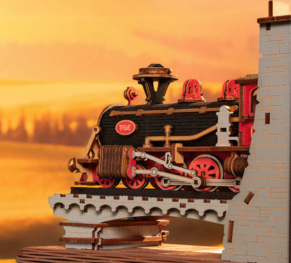 Model train on a bridge with a sunset background