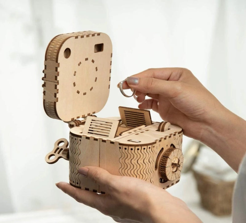 Wooden mechanical model being assembled by a person with a white background